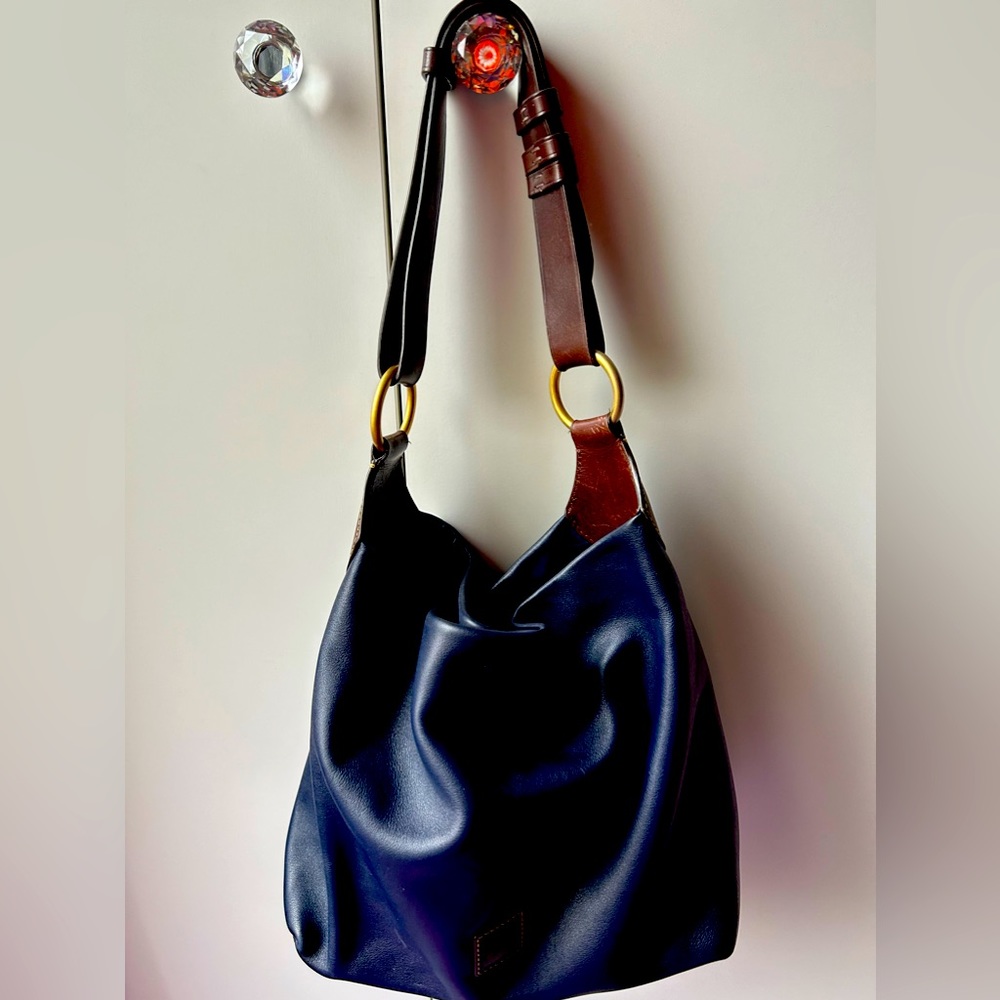 Navy blue satchel with magnetic closure. Gold accents